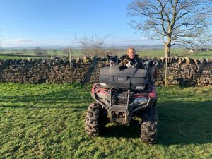shepherd and dogs on quad bike